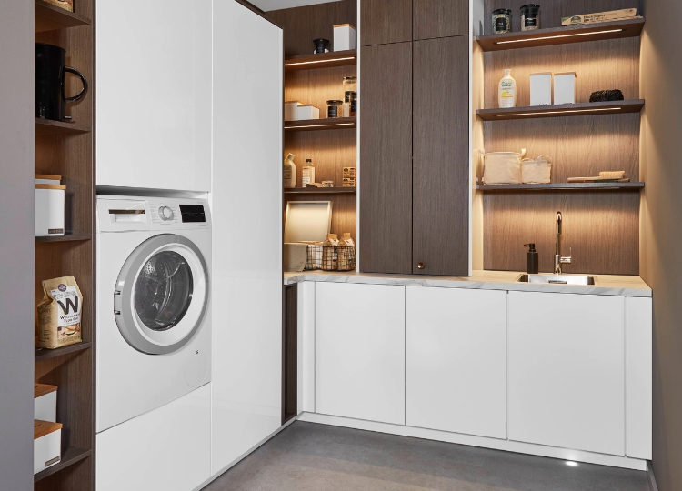 Moderner Hauswirtschaftsraum mit Waschmaschine, Spüle, Arbeitsfläche und Holzregalen
