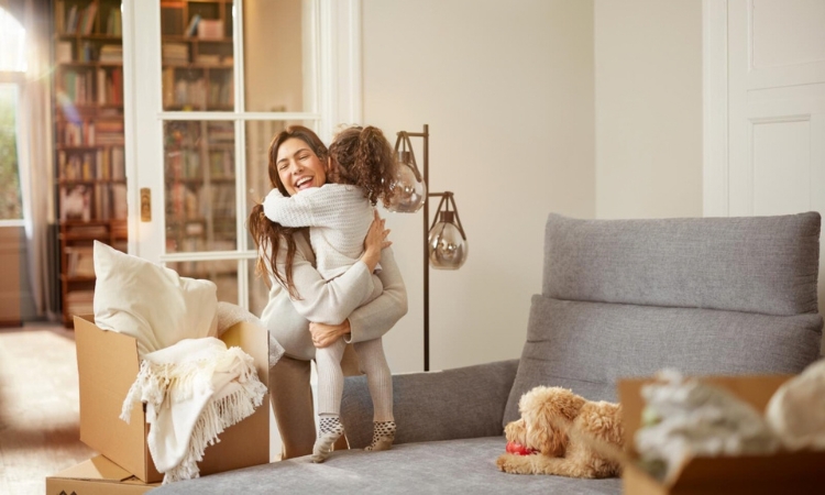Mutter und Kind sitzen entspannt in einem fertig eingerichteten Wohnzimmer