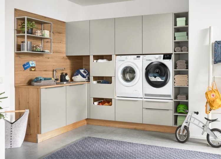 Moderner Hauswirtschaftsraum mit Waschmaschine, Trockner, Spüle und viel Stauraum