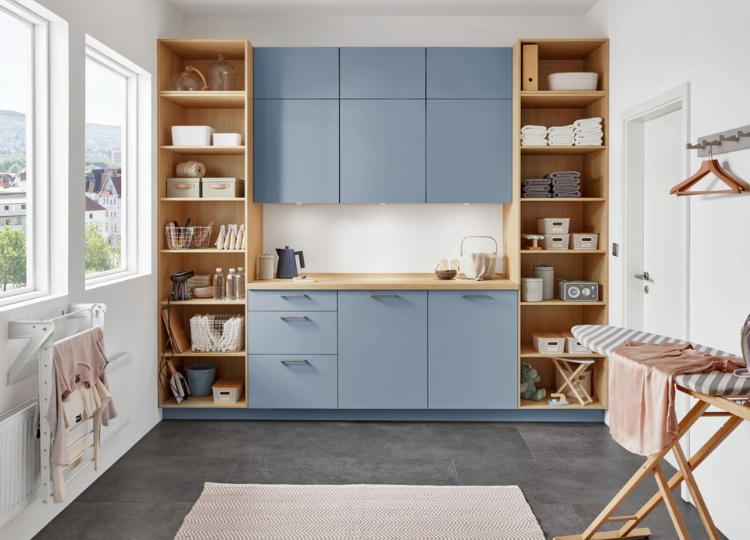 Blauer Hauswirtschaftsraum mit Arbeitsfläche, offenen Holzregalen und Stauraum