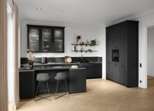 Schwarze moderne Landhausküche mit Rahmenfronten und warmen Holzdetails