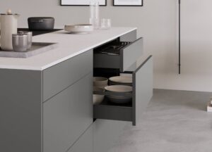 Schwarze grifflose Küche mit geöffnetem Schubkasten und glatten Fronten